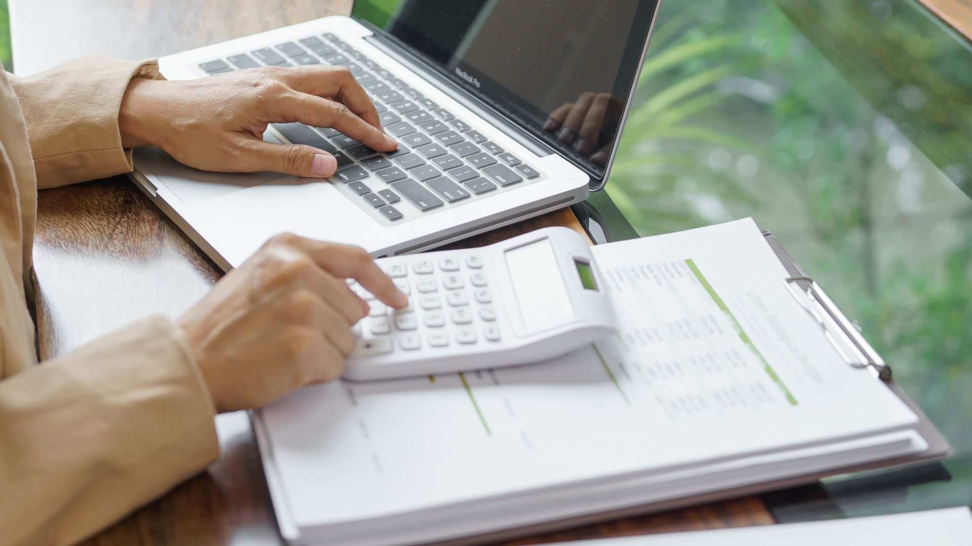 Business owner calculating ATO debt and reviewing financial documents on laptop